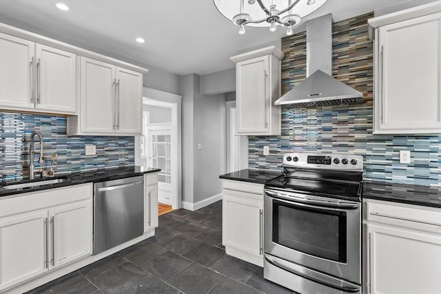 kitchen with wall chimney range hood, dark countertops, a sink, stainless steel appliances, and tasteful backsplash