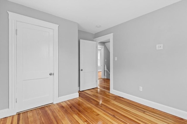 unfurnished bedroom with baseboards and light wood-style floors