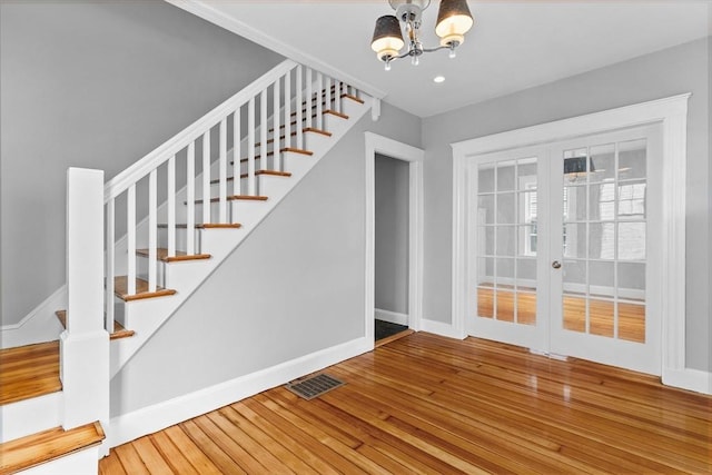 interior space with wood-type flooring, stairs, visible vents, and french doors
