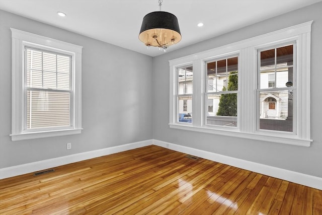 unfurnished room with a notable chandelier, recessed lighting, baseboards, light wood-type flooring, and visible vents