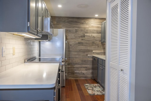140 Heritage Dr Unit 140, Northbridge, MA 01588 - kitchen with range, wood walls, backsplash, light countertops, and dark wood-type flooring