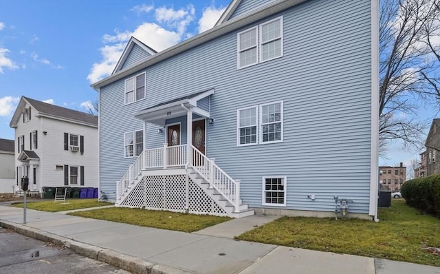 view of front of house featuring a front lawn and central air condition unit