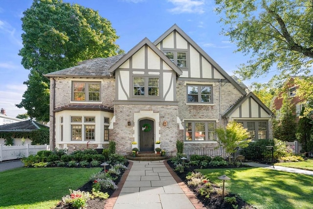 tudor-style house featuring a front lawn