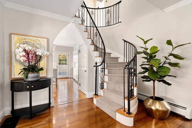 entryway featuring ornamental molding, hardwood / wood-style floors, and baseboard heating