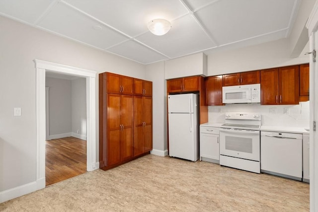 50-52 Linden Pl, Brookline, MA 02446 - kitchen featuring white appliances, light countertops, baseboards, and brown cabinets