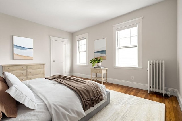 50-52 Linden Pl, Brookline, MA 02446 - bedroom with radiator, baseboards, and wood finished floors