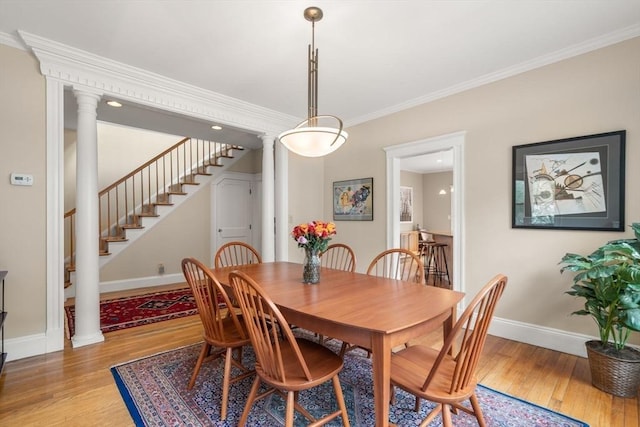 50-52 Linden Pl, Brookline, MA 02446 - dining room with baseboards, light wood-style floors, decorative columns, ornamental molding, and stairway