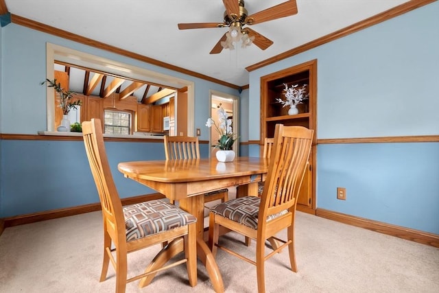 dining space featuring light carpet, a ceiling fan, baseboards, and ornamental molding