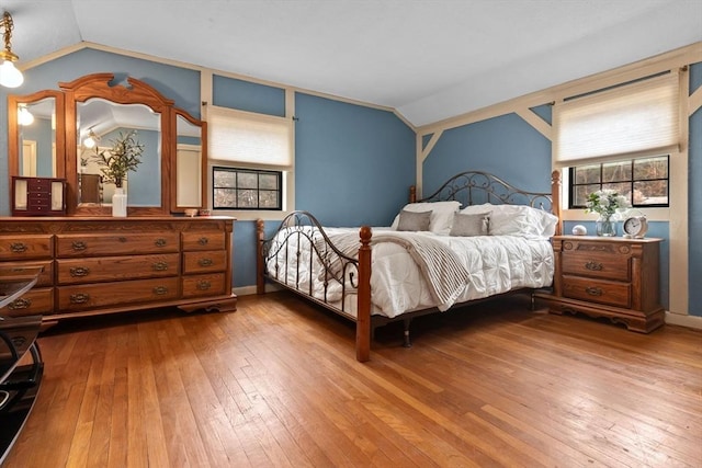 bedroom featuring baseboards, lofted ceiling, and hardwood / wood-style flooring