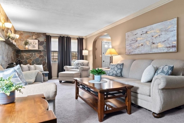 living area featuring arched walkways, crown molding, and carpet