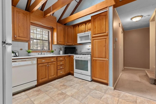 kitchen featuring a sink, backsplash, white appliances, light countertops, and vaulted ceiling with beams