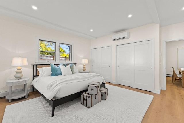 354 Gifford Unit 1, Falmouth, MA 02540 - bedroom featuring an AC wall unit, two closets, light wood-style floors, recessed lighting, and baseboard heating