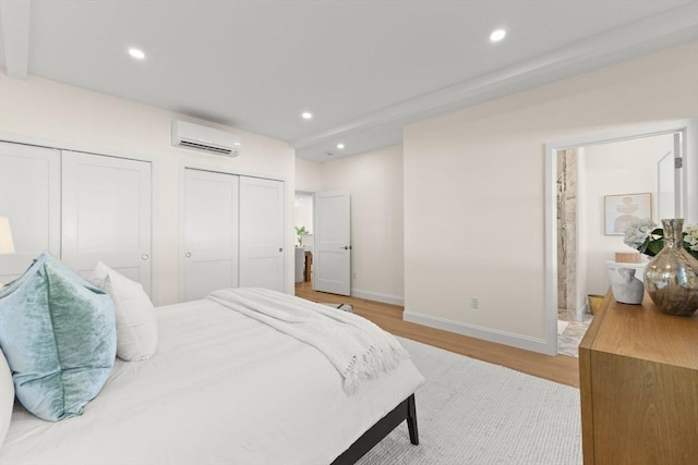 354 Gifford Unit 1, Falmouth, MA 02540 - bedroom featuring an AC wall unit, two closets, light wood finished floors, baseboards, and recessed lighting