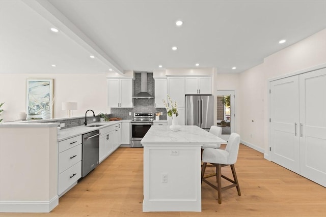 354 Gifford Unit 1, Falmouth, MA 02540 - kitchen featuring stainless steel appliances, wall chimney range hood, a kitchen bar, a sink, and a center island