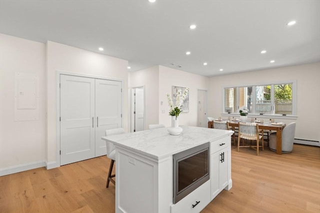 354 Gifford Unit 1, Falmouth, MA 02540 - kitchen with stainless steel microwave, a baseboard heating unit, light wood-type flooring, a center island, and recessed lighting