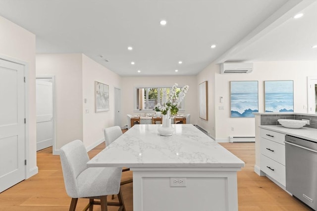 354 Gifford Unit 1, Falmouth, MA 02540 - kitchen with dishwasher, a wall mounted AC, a kitchen island, white cabinets, and light wood finished floors