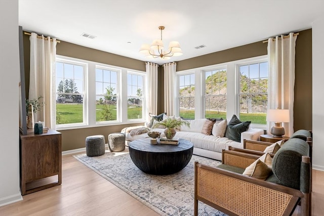 sunroom / solarium with visible vents and an inviting chandelier