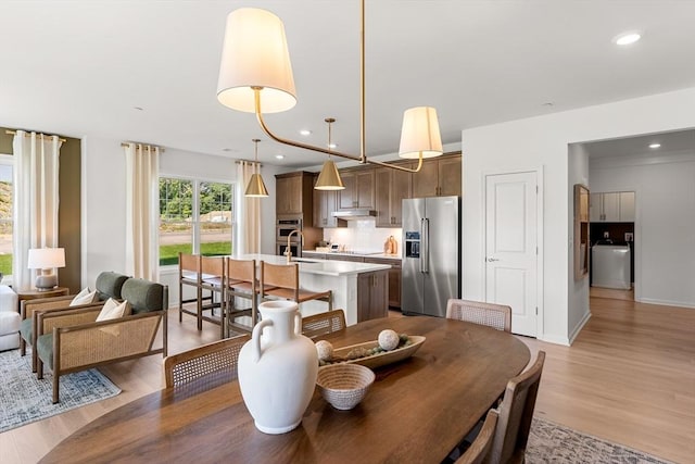 dining area with recessed lighting, baseboards, washer / dryer, and light wood-type flooring