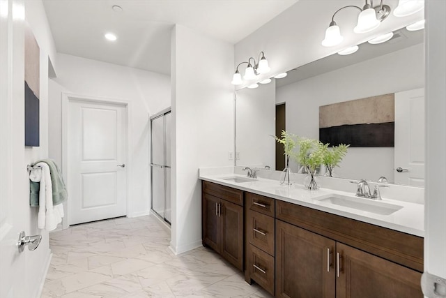bathroom featuring a shower stall, marble finish floor, a sink, and double vanity