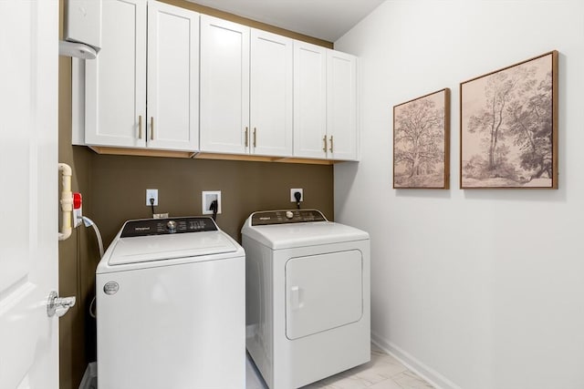 laundry area featuring marble finish floor, baseboards, cabinet space, and washer and clothes dryer