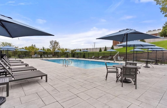 community pool with fence and a patio