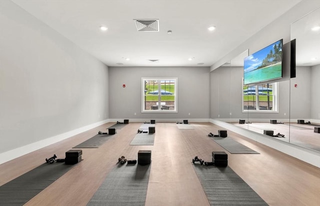 workout area featuring recessed lighting, light wood-style flooring, visible vents, and baseboards