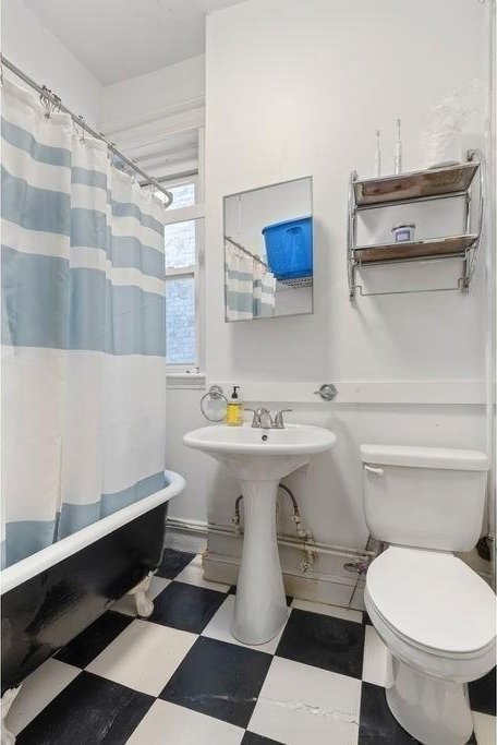 bathroom with tile patterned floors, toilet, and shower / bathtub combination with curtain