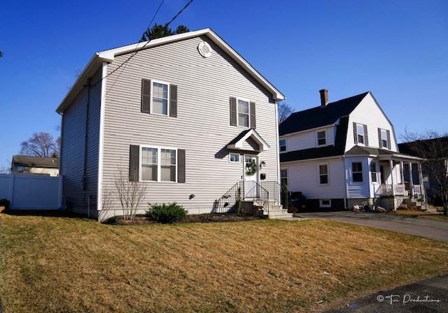 rear view of house featuring a lawn