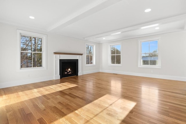 unfurnished living room with beam ceiling, light hardwood / wood-style flooring, and ornamental molding