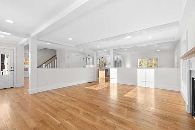 unfurnished living room featuring crown molding, beamed ceiling, and light wood-type flooring