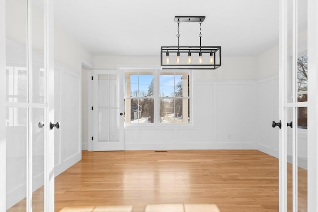 unfurnished dining area with french doors and hardwood / wood-style floors