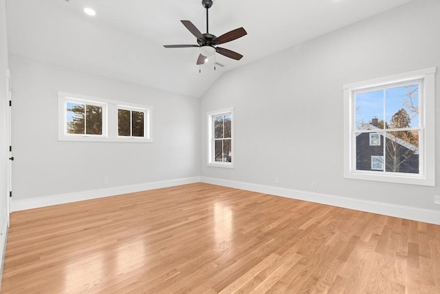 empty room with ceiling fan, lofted ceiling, plenty of natural light, and light hardwood / wood-style floors