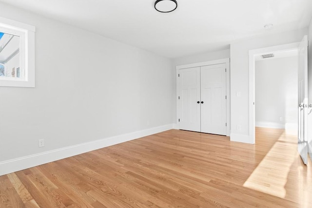 unfurnished bedroom featuring light hardwood / wood-style floors and a closet