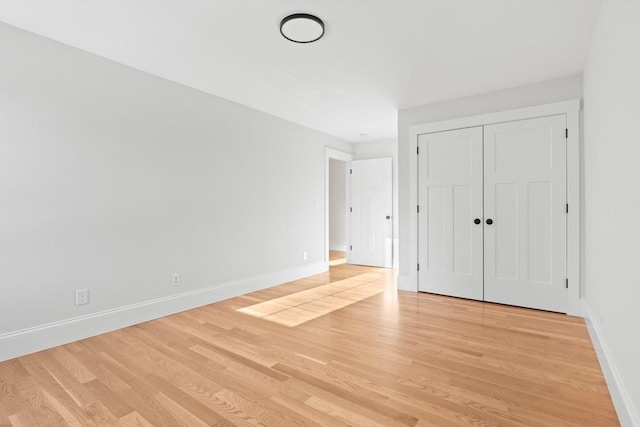 unfurnished bedroom with light wood-type flooring and a closet