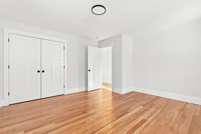 unfurnished bedroom with light hardwood / wood-style flooring and a closet