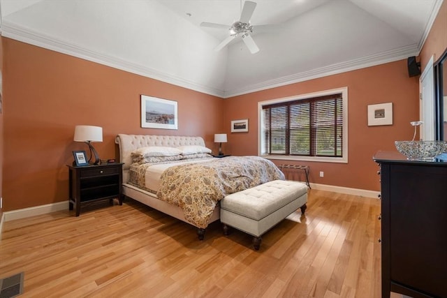 bedroom with visible vents, crown molding, vaulted ceiling, baseboards, and light wood-style floors