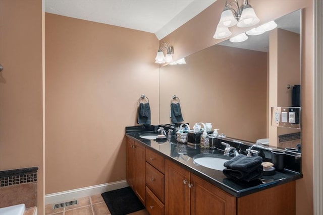 full bath featuring double vanity, tile patterned floors, a chandelier, and a sink