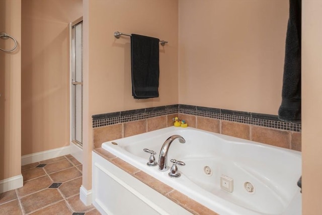 full bathroom featuring baseboards, tile patterned flooring, a whirlpool tub, and a stall shower