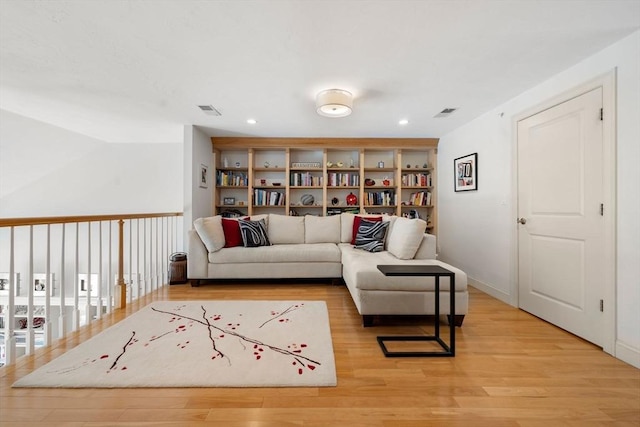 living area with recessed lighting, light wood-style flooring, and visible vents