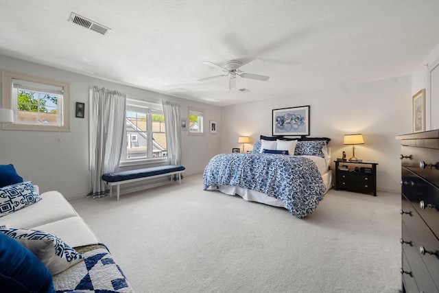 bedroom featuring multiple windows, light carpet, ceiling fan, and visible vents