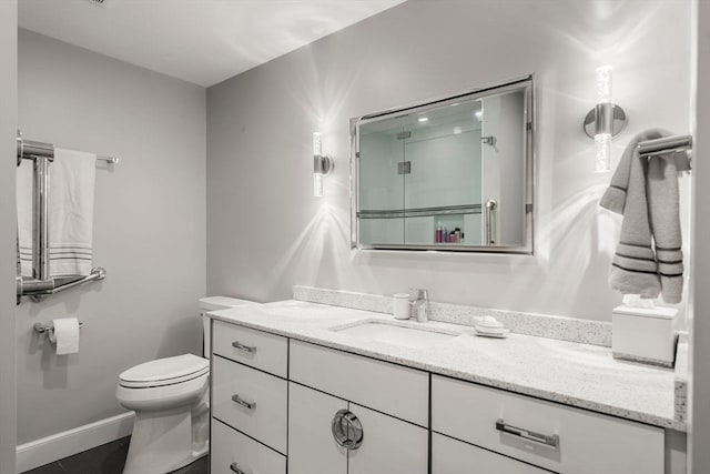 full bathroom with vanity, toilet, baseboards, and a stall shower