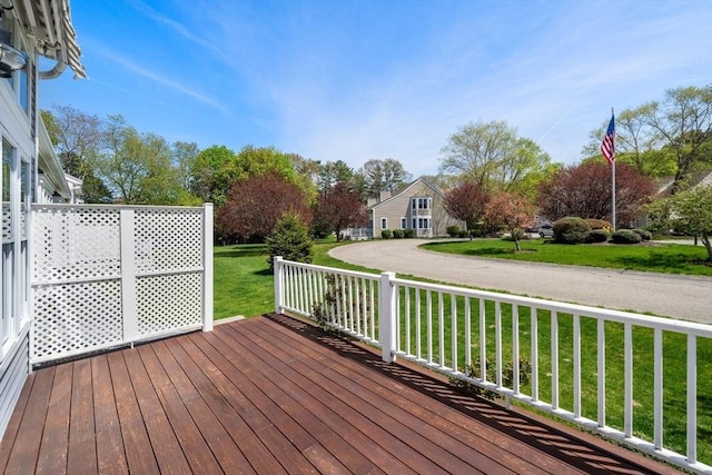 wooden terrace featuring a lawn