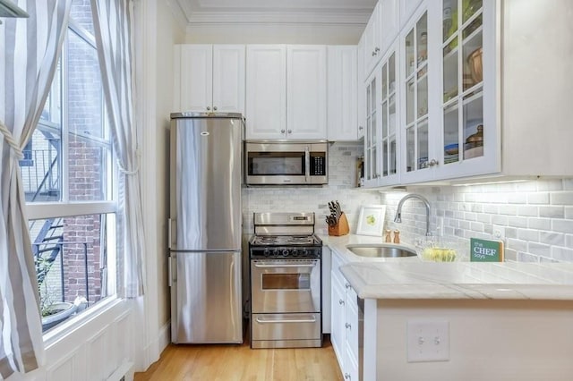 376 Marlborough St Unit 4, Boston, MA 02116 - kitchen featuring appliances with stainless steel finishes, white cabinets, backsplash, plenty of natural light, and crown molding
