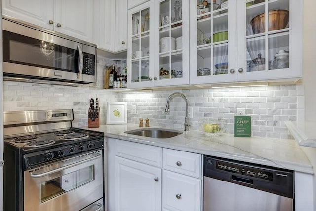 376 Marlborough St Unit 4, Boston, MA 02116 - kitchen with appliances with stainless steel finishes, white cabinetry, backsplash, and light stone counters