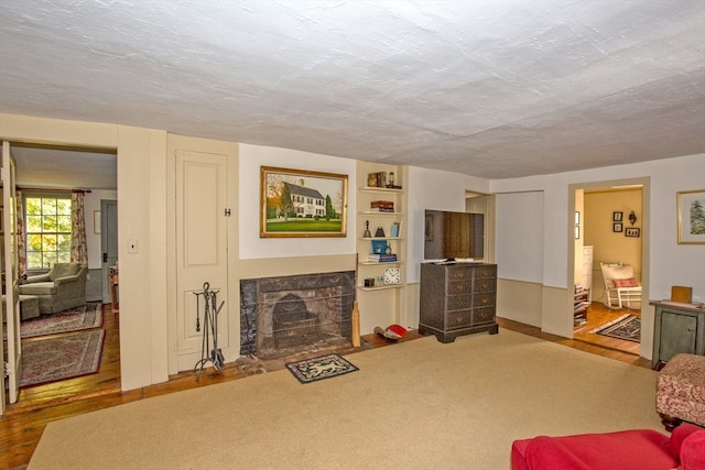 living room with a high end fireplace, a textured ceiling, and hardwood / wood-style floors