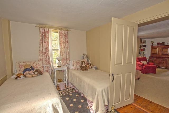 bedroom with a textured ceiling and hardwood / wood-style flooring