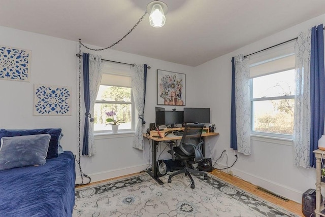 home office with a wealth of natural light and wood-type flooring