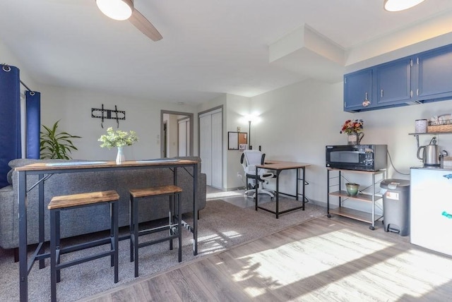 kitchen with blue cabinetry, light hardwood / wood-style flooring, and ceiling fan