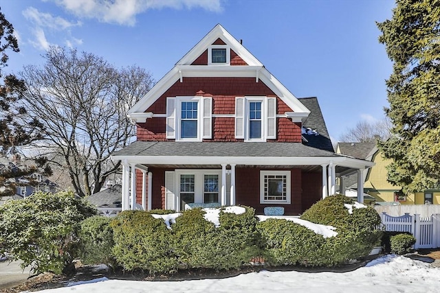 shingle-style home featuring fence and a porch