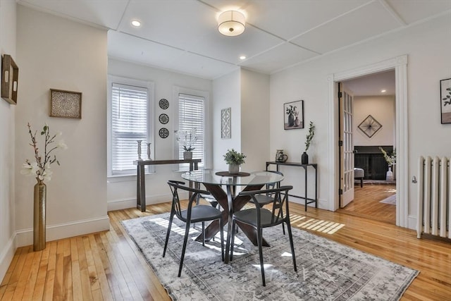 dining space featuring light wood-style floors, recessed lighting, radiator, and baseboards